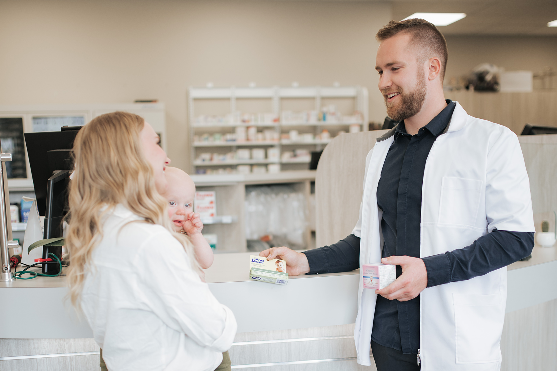 Pharmacist and a customer chatting at the reception desk
