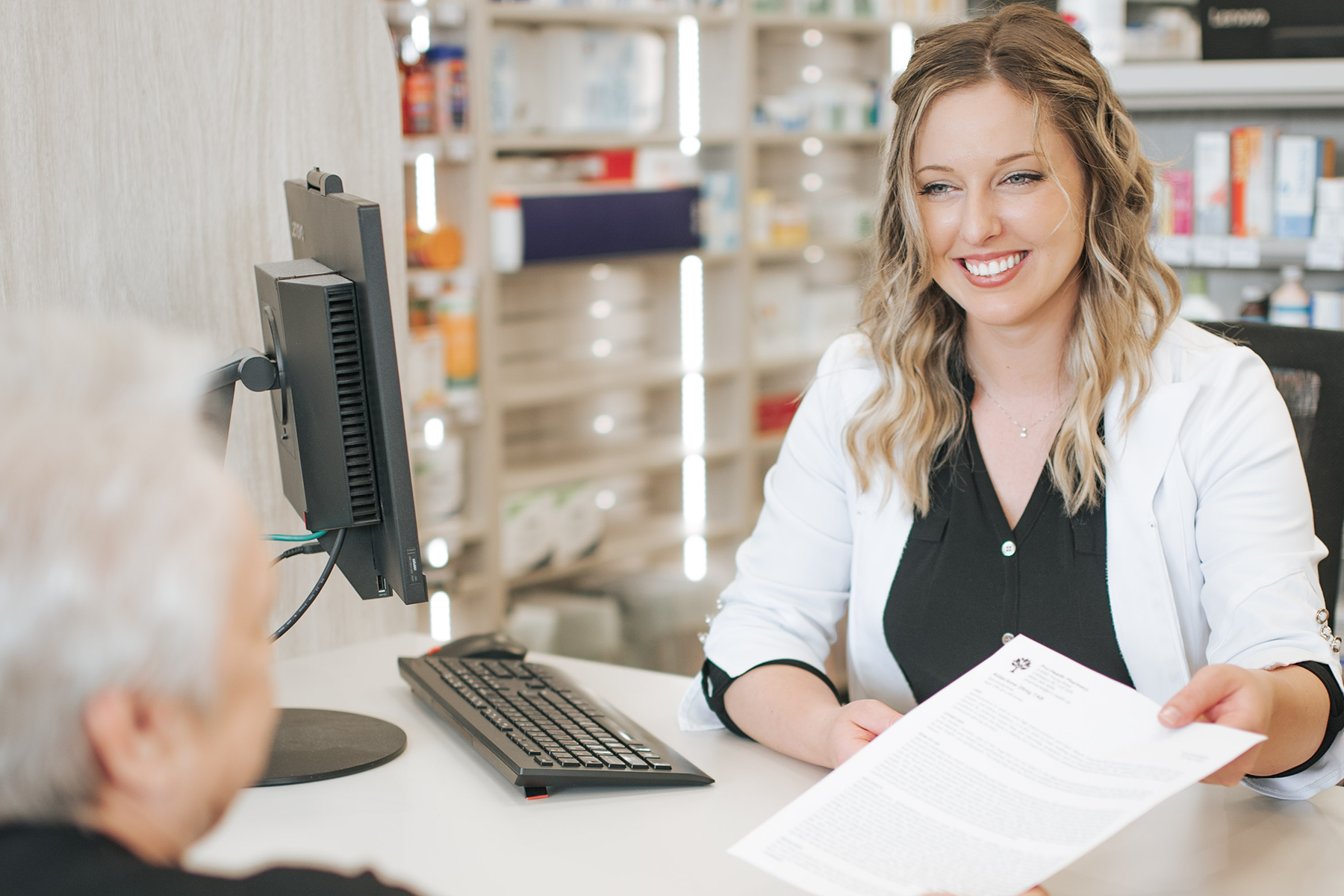 Pharmacist and customer meeting at the registration desk of the pharmacy